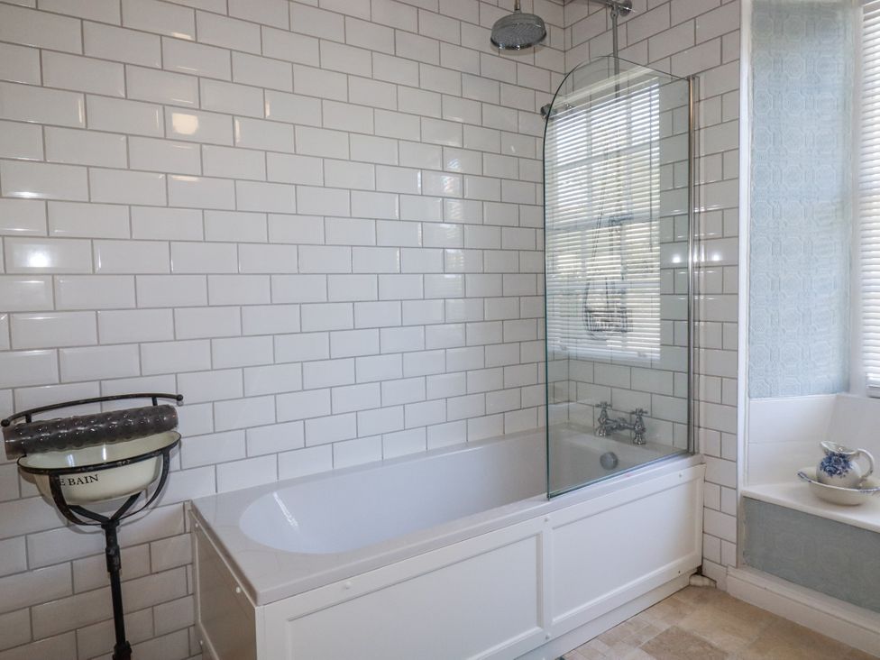 A bathroom with a bathtub and shower screen at Rosedale in St. Ives