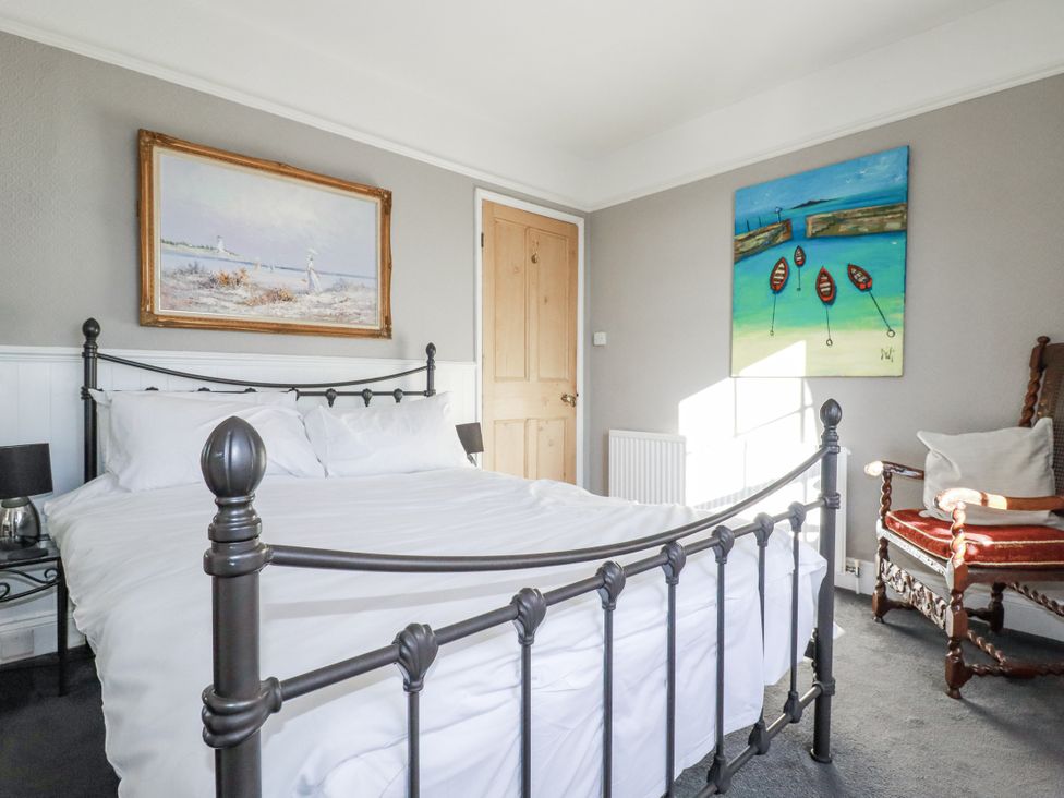 A bedroom with a bed and paintings at Rosedale in St. Ives