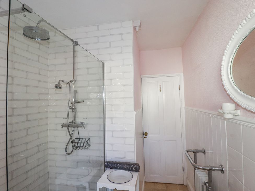 A bathroom with a shower, toilet, and mirror at Rosedale in St. Ives