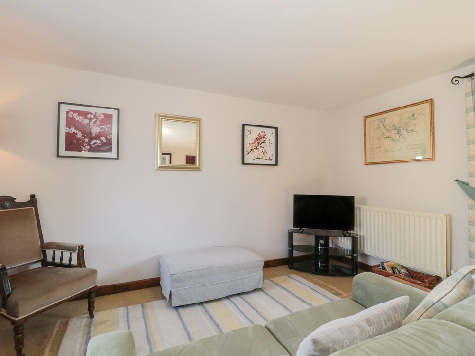 A living room with a sofa and television at The Cowshed in Bristol
