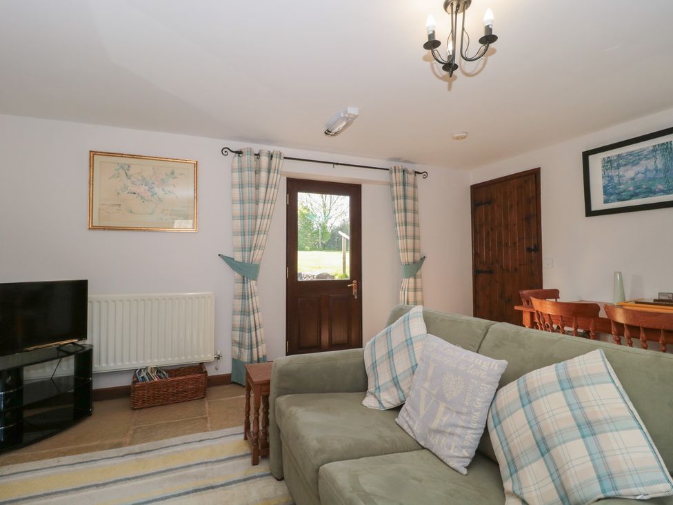 A living room with a sofa and television at The Cowshed in Bristol