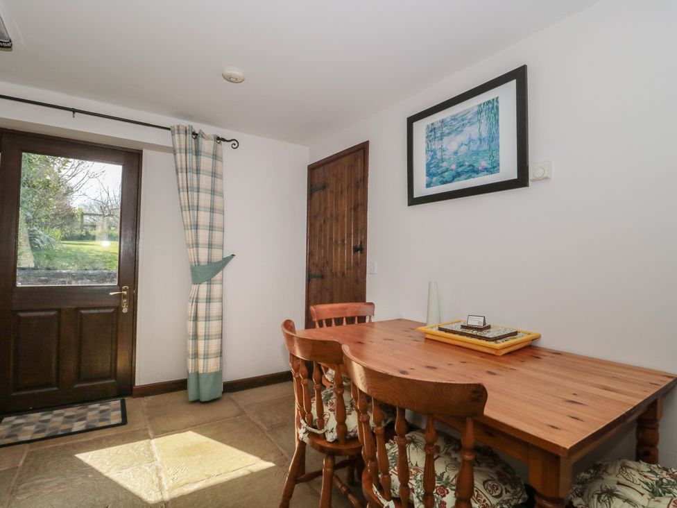 A dining room with a table and chairs at The Cowshed in Bristol