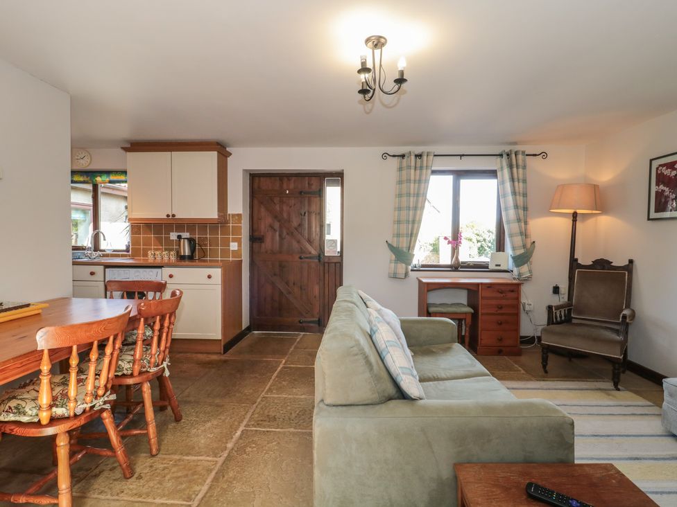 A living room with a dining table and chairs at The Cowshed in Bristol