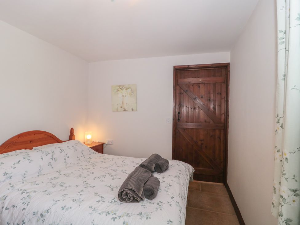 A bedroom with a bed and a wooden door at The Cowshed in Bristol