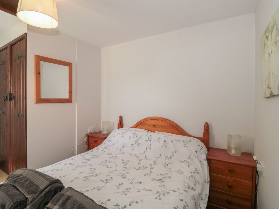 A bedroom with a bed and nightstand at The Cowshed in Bristol