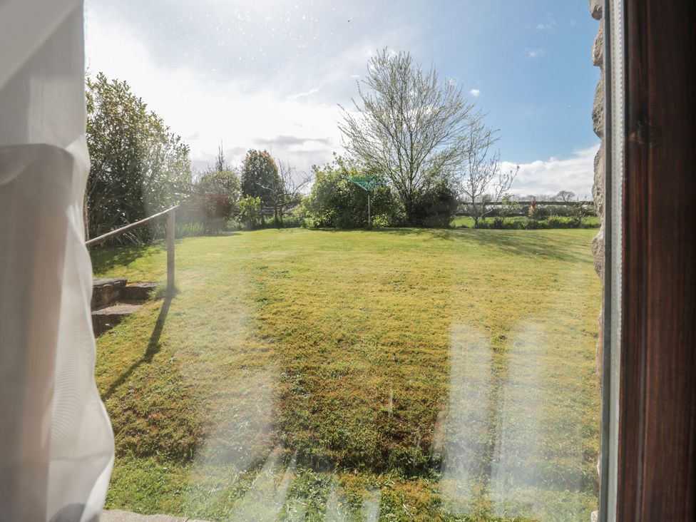A view of a garden with grass and trees at The Cowshed in Bristol
