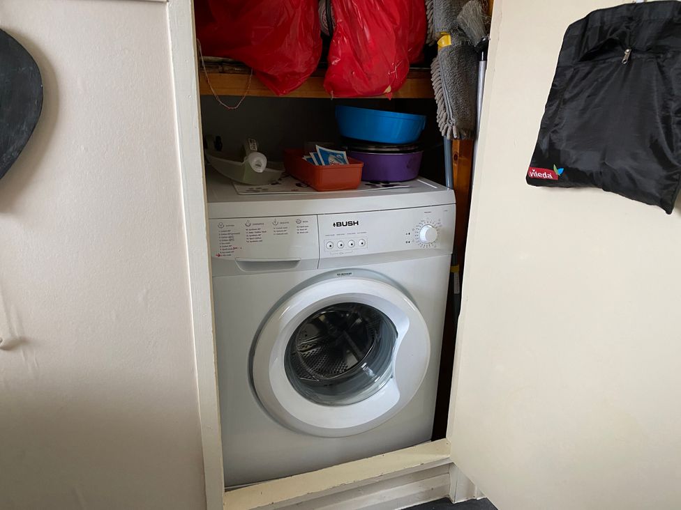 A washing machine with bowls and cleaning supplies at 300 California Sands, California, Norfolk