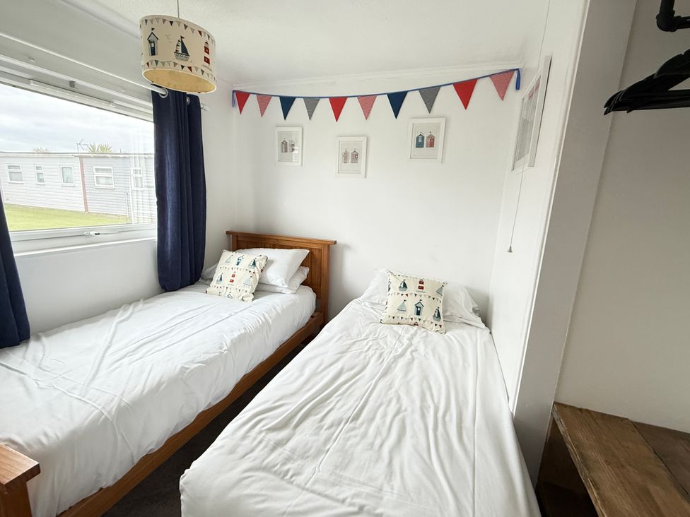A bedroom with two beds and bunting at 300 California Sands, California, Norfolk