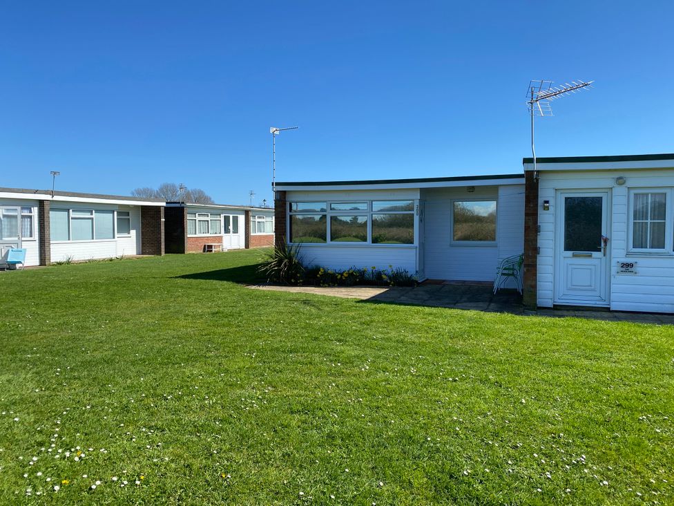 An outdoor area with cottages and grass at 300 California Sands in California, Norfolk