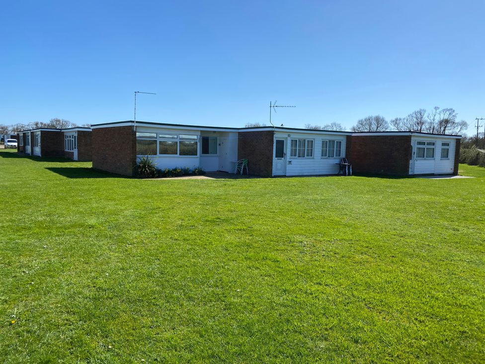 A bungalow with a lawn and clear blue sky at 300 California Sands, California, Norfolk
