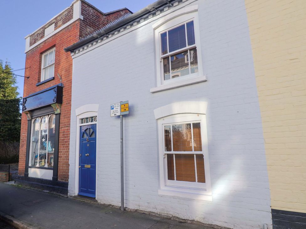 A building with a blue door and windows at Rope Cottage in Bridport