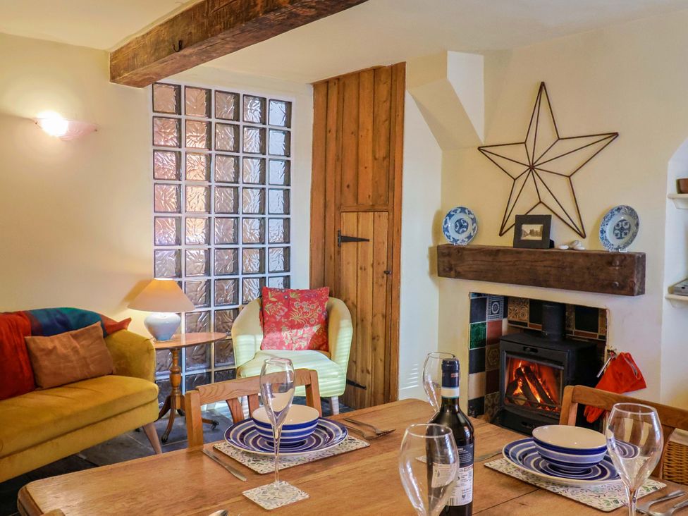 A dining room with a table set for a meal at Rope Cottage in Bridport