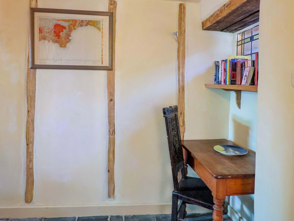 A study area with a desk and bookshelves at Rope Cottage in Bridport