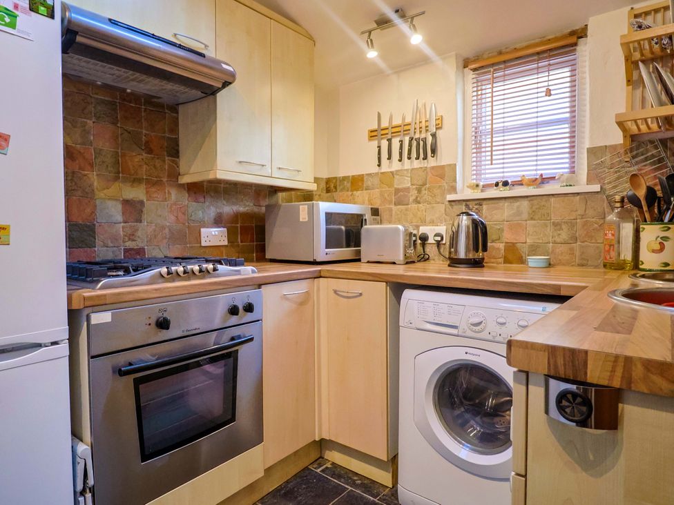 A kitchen with appliances and cabinets at Rope Cottage in Bridport