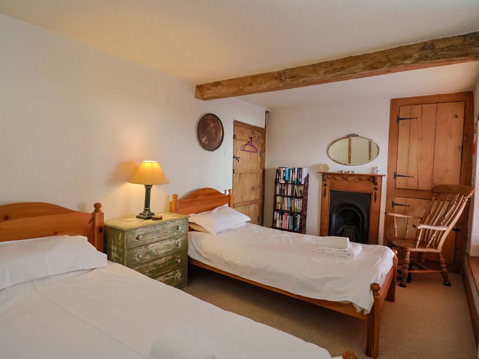 A bedroom with two beds and furniture at Rope Cottage in Bridport
