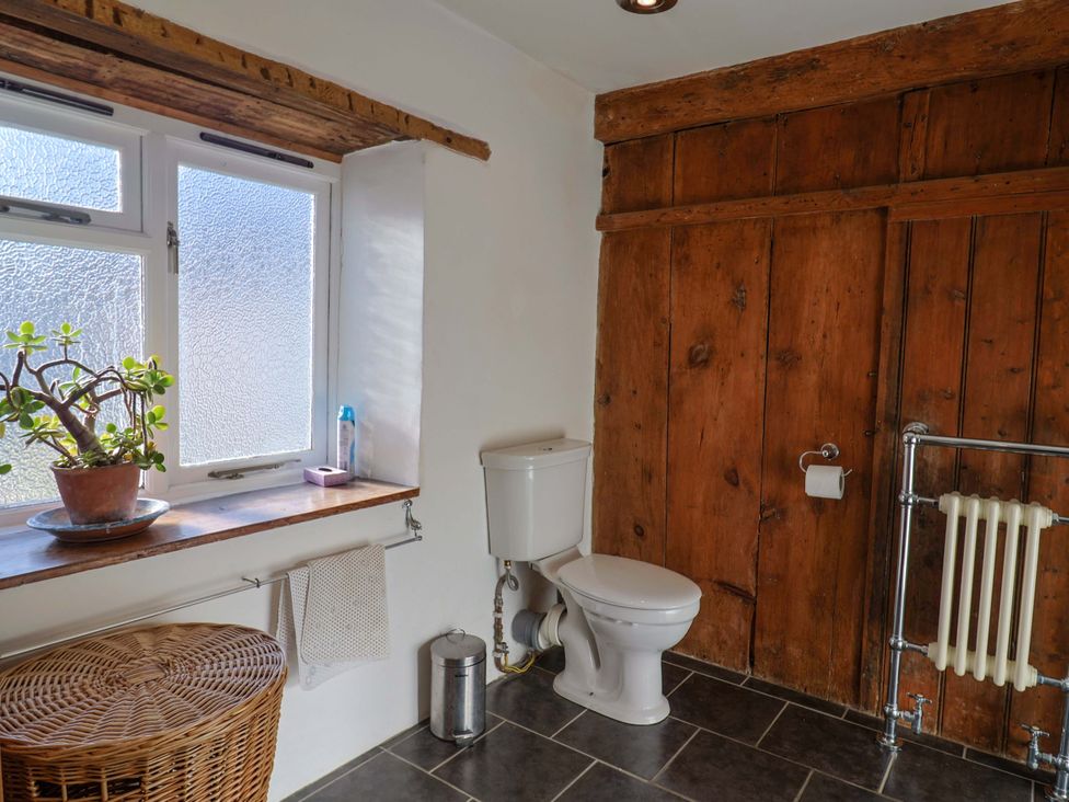 A bathroom with a toilet and a window at Rope Cottage in Bridport