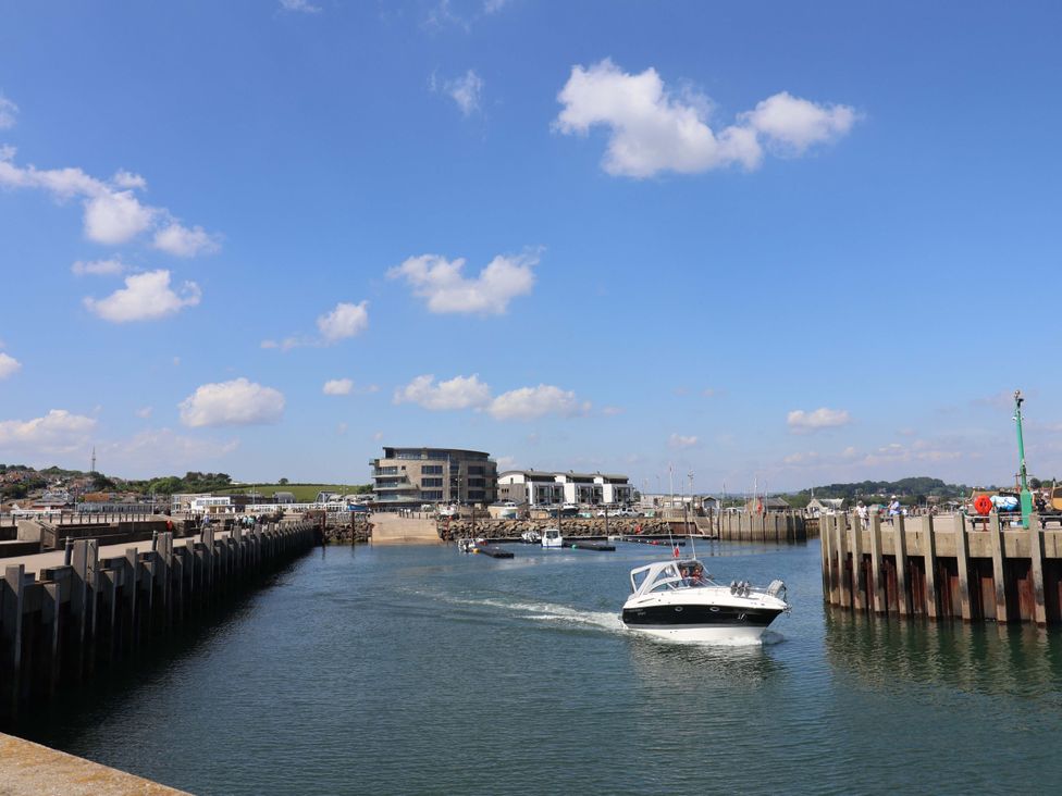 A view of a marina with boats and buildings at Rope Cottage in Bridport