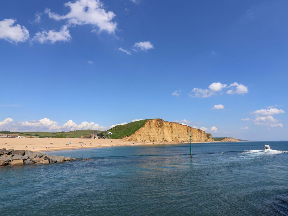 A beach with cliffs and water at Rope Cottage in Bridport