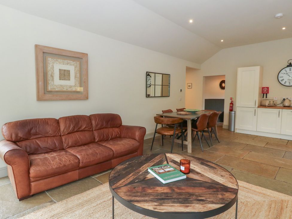 A living room with a sofa and dining area at Glen Lochay Lodge in Killin