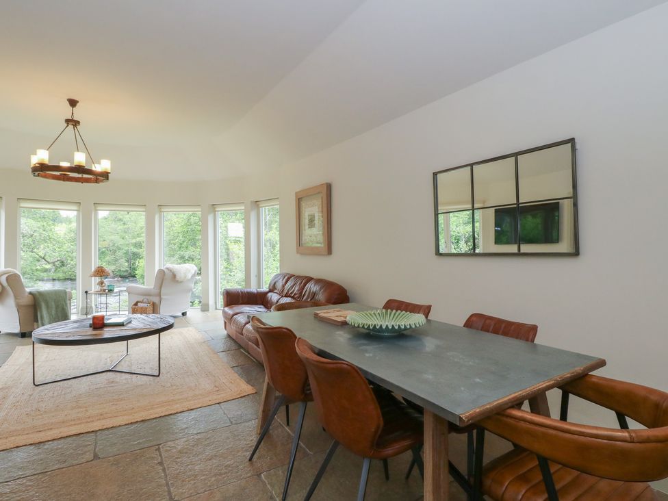 A living room with a sofa and dining table at Glen Lochay Lodge in Killin