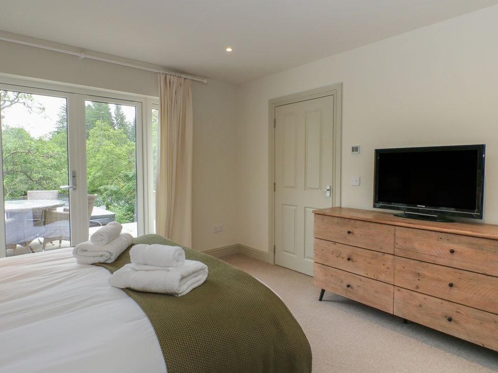 A bedroom with a bed and a television at Glen Lochay Lodge in Killin