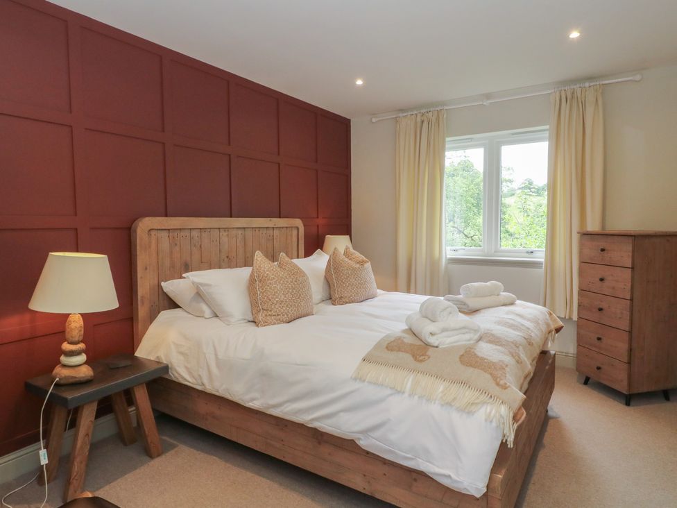 A bedroom with a bed and dressing table at Glen Lochay Lodge in Killin