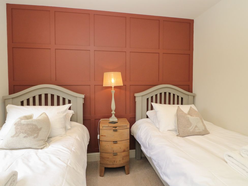 A bedroom with two single beds and a lamp at Glen Lochay Lodge in Killin