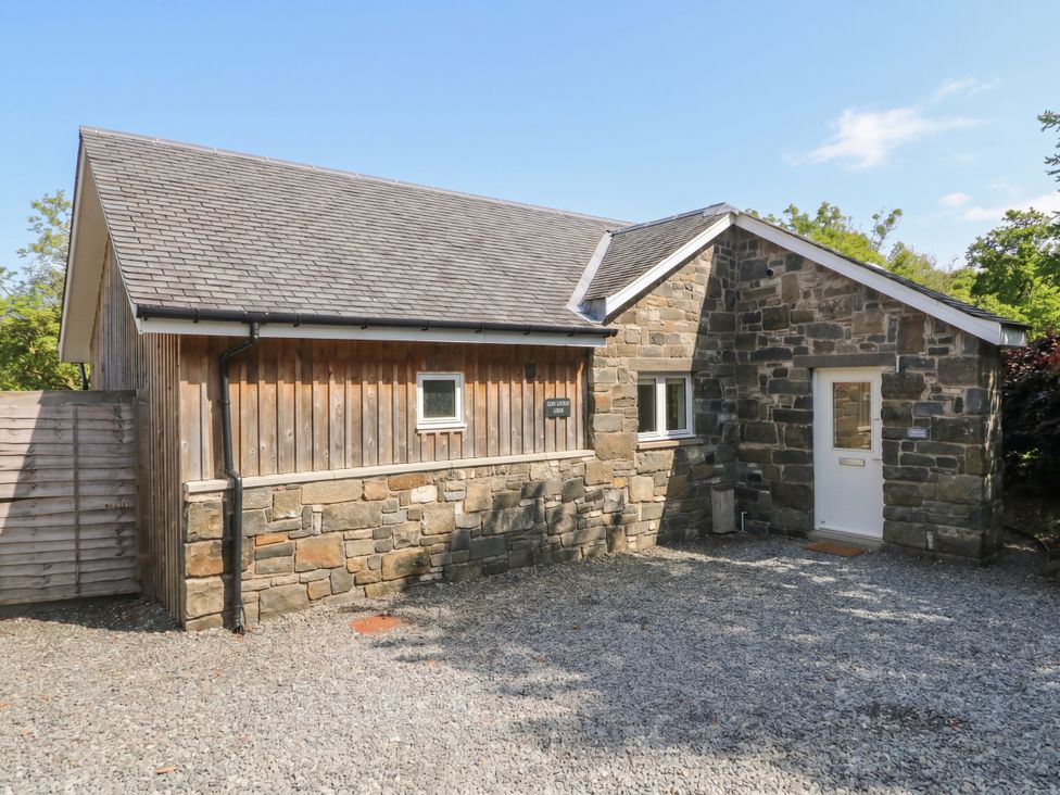 A building with a stone facade and gravel area at Glen Lochay Lodge in Killin