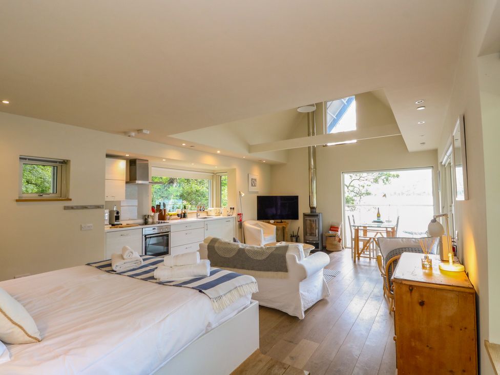 A living room with a kitchen and dining area at Osprey Boathouse in Killin