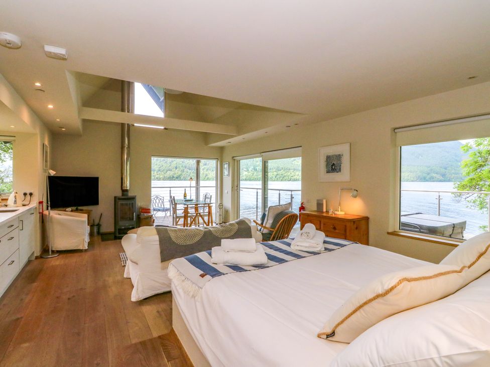 A bedroom with a bed and a couch at Osprey Boathouse in Killin