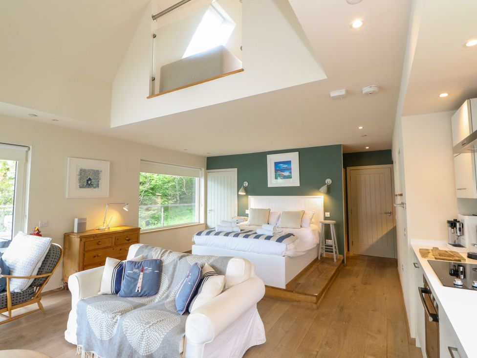 A bedroom with a bed and sofa at Osprey Boathouse in Killin