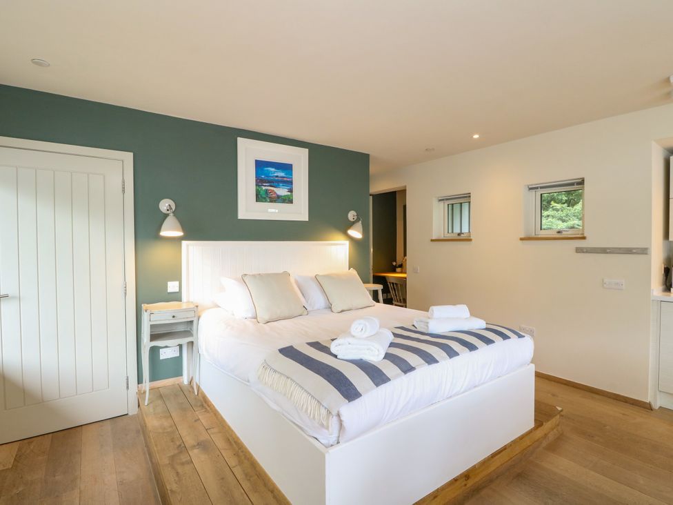A bedroom with a bed and bedside table at Osprey Boathouse in Killin