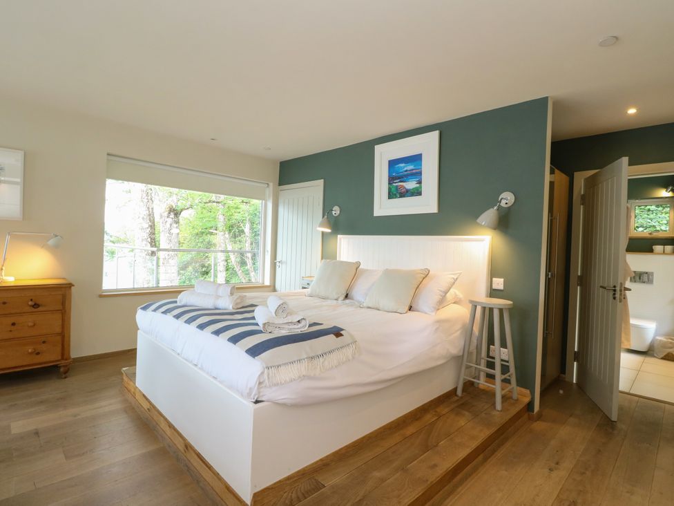 A bedroom with a bed and dresser at Osprey Boathouse in Killin