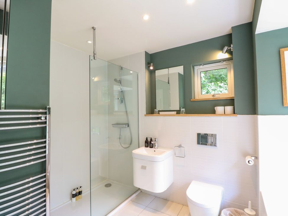 A bathroom with a shower, toilet, and sink at Osprey Boathouse in Killin