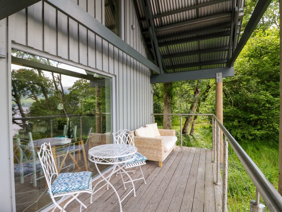 An outdoor seating area with a table and chairs at Osprey Boathouse in Killin