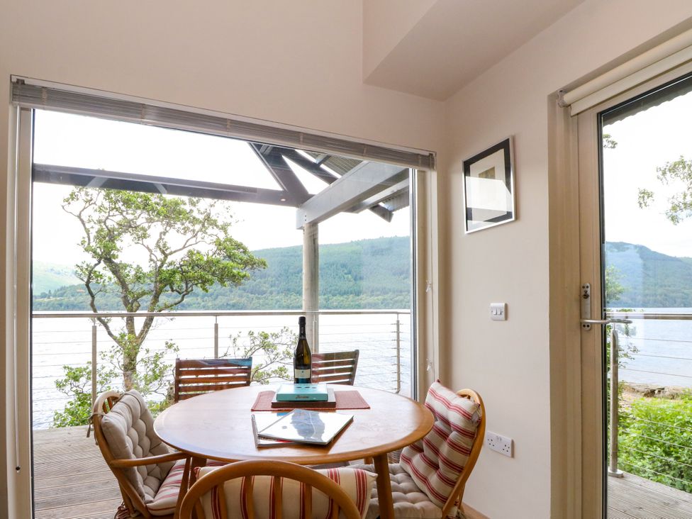 A dining room with a table and chairs at Dipper Boathouse in Killin