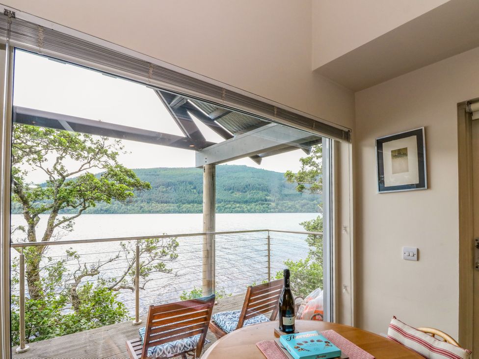 A dining room with a table and chairs at Dipper Boathouse in Killin
