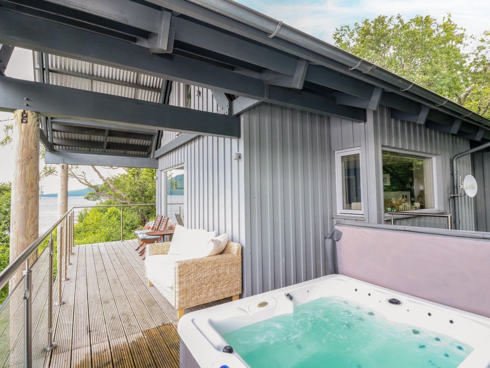 An outdoor area with a hot tub and a couch at Dipper Boathouse in Killin