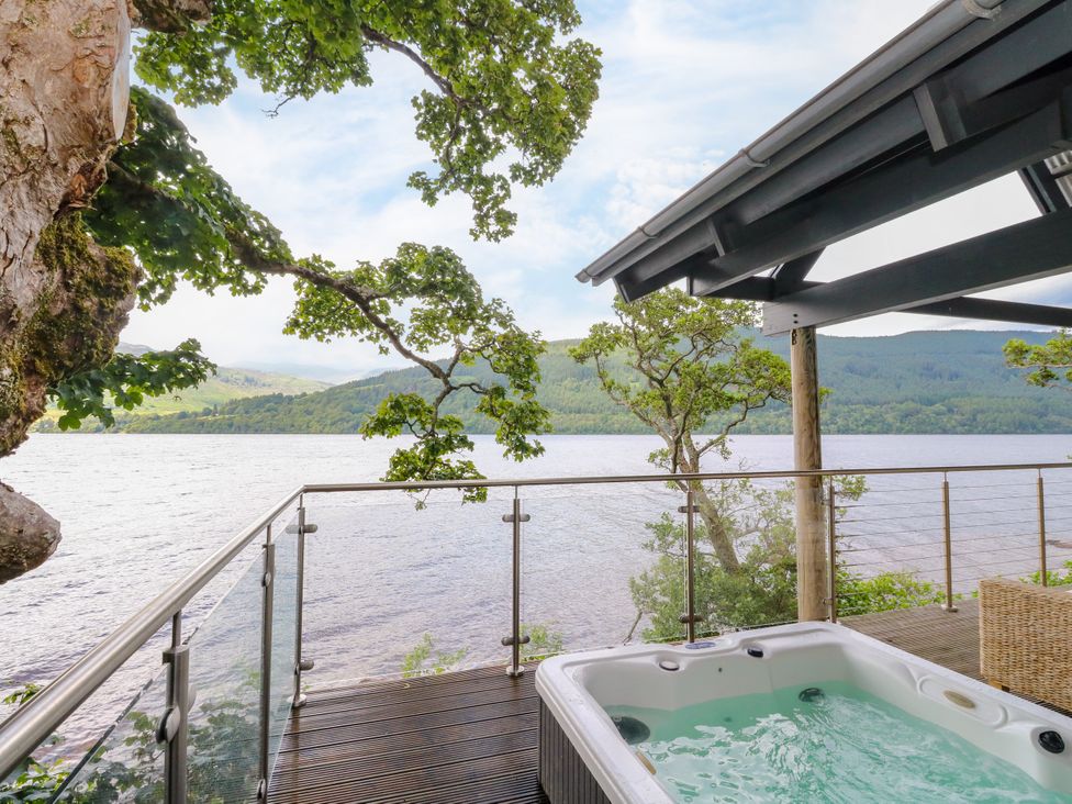 An outdoor area featuring a jacuzzi by a lake at Dipper Boathouse in Killin