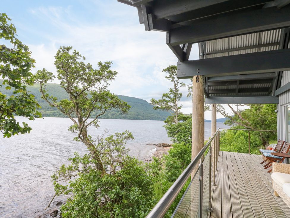 A deck with a view of water and trees at Dipper Boathouse in Killin