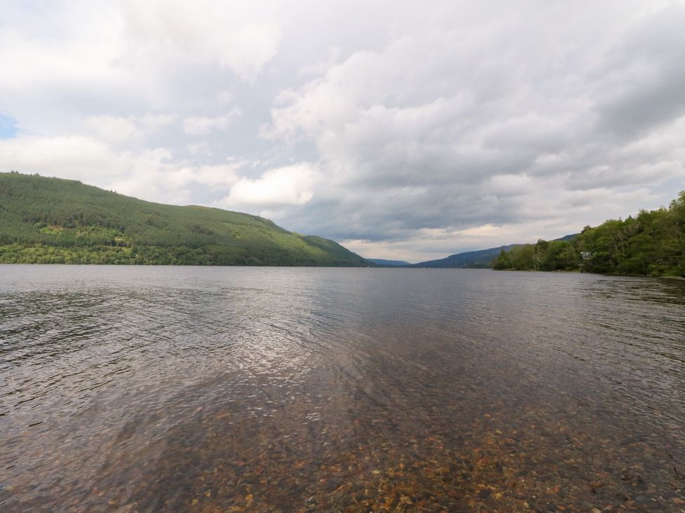 A lake surrounded by mountains and a cloudy sky at Dipper Boathouse in Killin