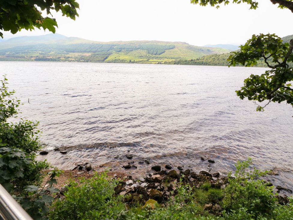 A lakeshore with rocks and trees at Dipper Boathouse in Killin