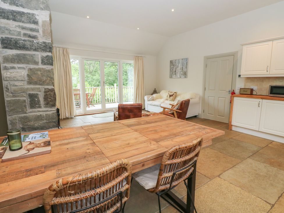 A living room with a wooden table and chairs at Ghillie's Cottage in Killin