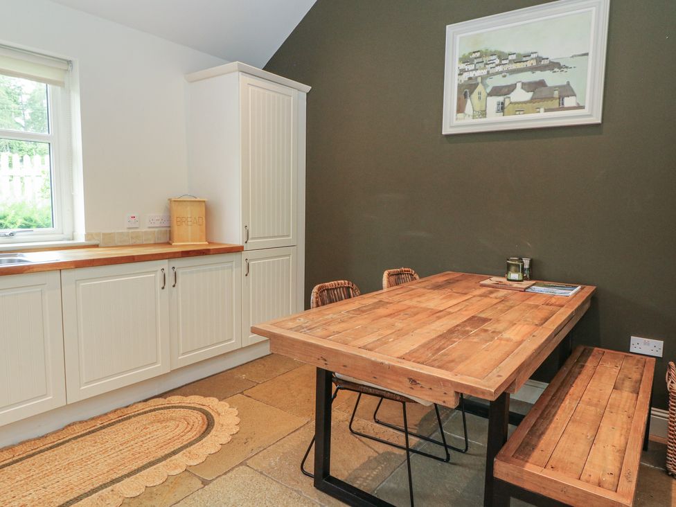 A kitchen with a dining table and chairs at Ghillie's Cottage in Killin