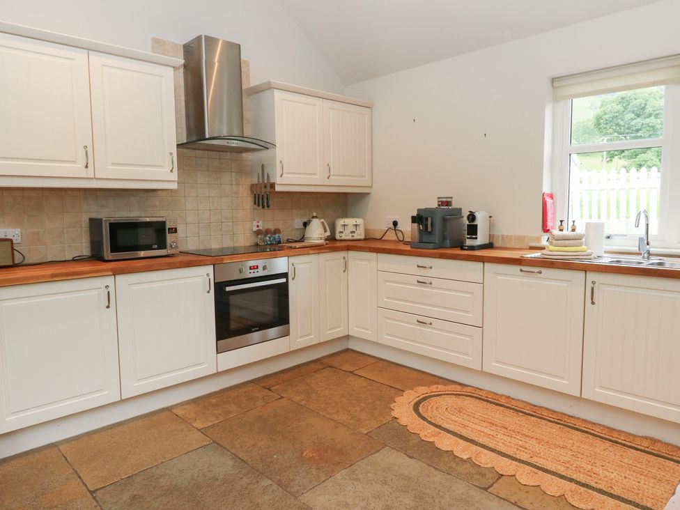 A kitchen with cabinets and appliances at Ghillie's Cottage in Killin