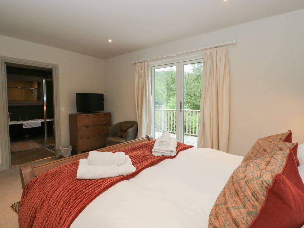 A bedroom with a bed and dresser at Ghillie's Cottage in Killin