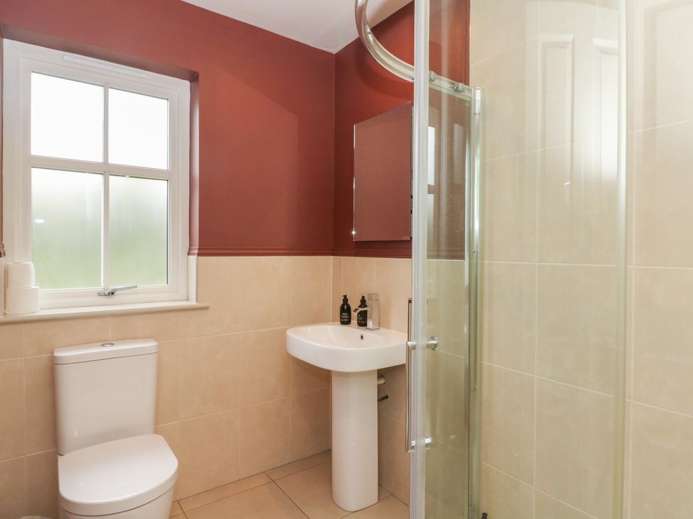 A bathroom with a toilet, sink, and shower at Ghillie's Cottage, Killin