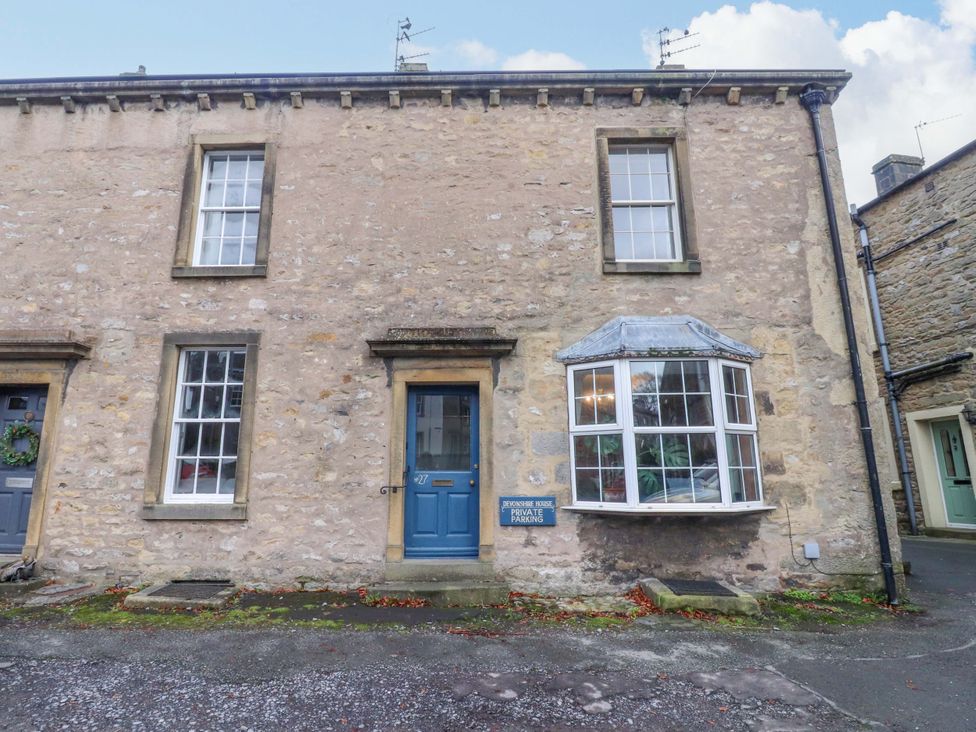 A house with windows and a blue door at Devonshire House Settle