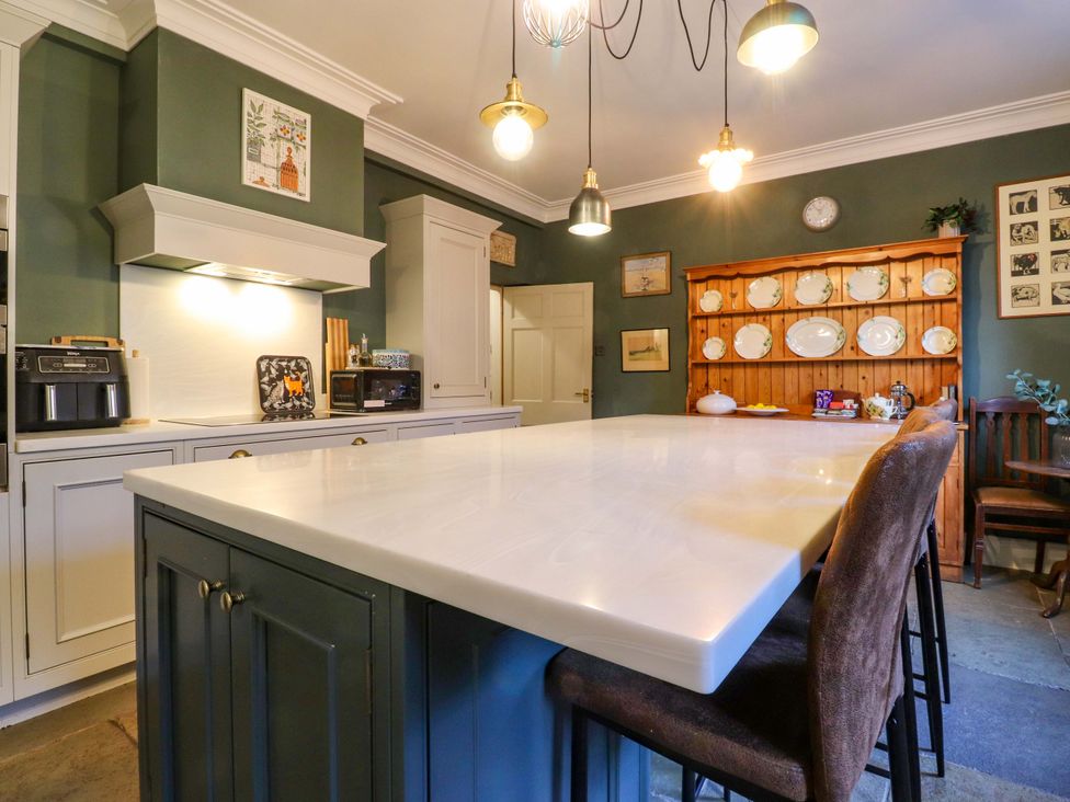 A kitchen with an island and cabinets at Devonshire House in Settle