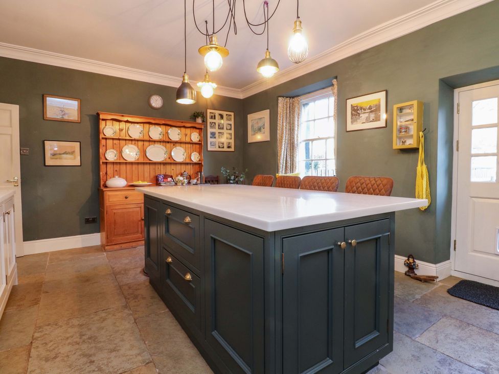 A kitchen with a central island and seating at Devonshire House in Settle